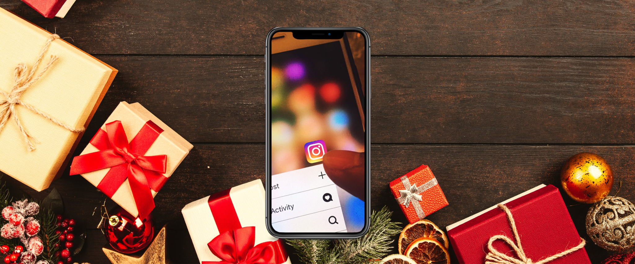 Handy auf einem Weihnachtstisch voller Geschenke, welches das Instagram Logo zeigt